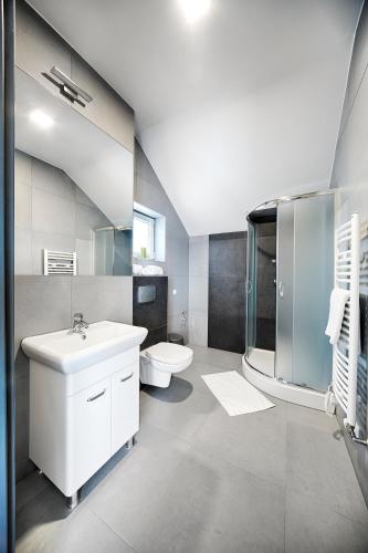 a bathroom with a sink and a toilet at Apartamenty Salt Delux in Wieliczka