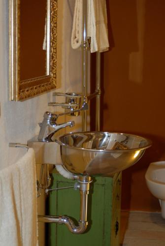 a bathroom with a silver sink with a mirror at Morelliana4Rooms in Scansano