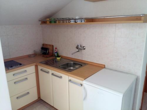 uma pequena cozinha com um lavatório e um balcão em Apartments Ćenan em Korčula