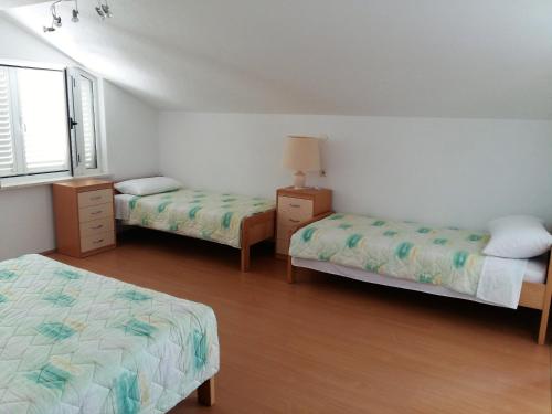 a bedroom with two beds and a window at Apartments Ćenan in Korčula