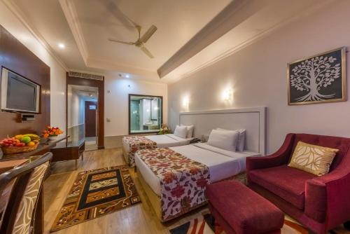 a hotel room with a bed and a chair at Hotel Hindusthan International, Bhubaneswar in Bhubaneshwar