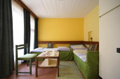 a hotel room with two beds and a table and a table sidx sidx at Hotel Melis in Balatonlelle