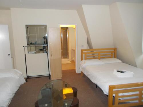 a room with two beds and a glass table at Citystay Hotel in London