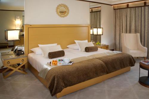 a hotel room with a large bed and a desk at Grande Real Villa Itália Hotel & Spa in Cascais