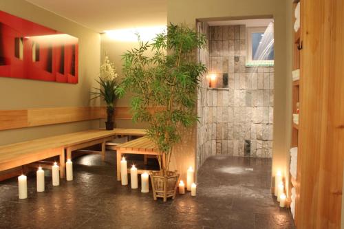 a room with a bench and candles and plants at Romantik Hotel Chalet am Kiental in Herrsching am Ammersee
