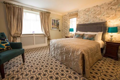 a bedroom with a bed and a chair and a window at Anner Hotel in Thurles