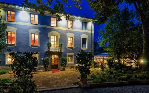 a large blue house with a courtyard at night at Resort Dei Limoni Tower Inn in Lucca