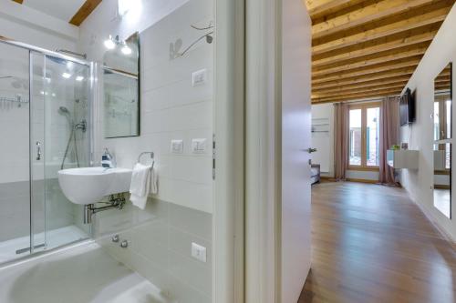 uma casa de banho com um lavatório e uma cabina de duche em vidro. em Appartamento Arco em Pádua