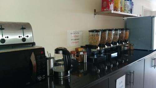 a kitchen with a counter with a coffee maker and a coffee maker at Ava House Bed and Breakfast in Bicester