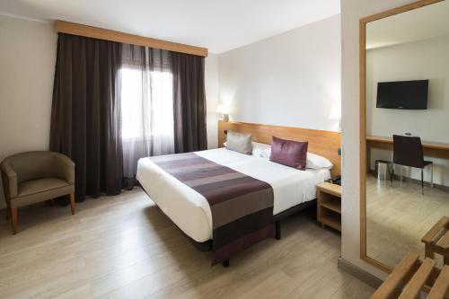 a hotel room with a large bed and a mirror at Catalonia Park Güell in Barcelona