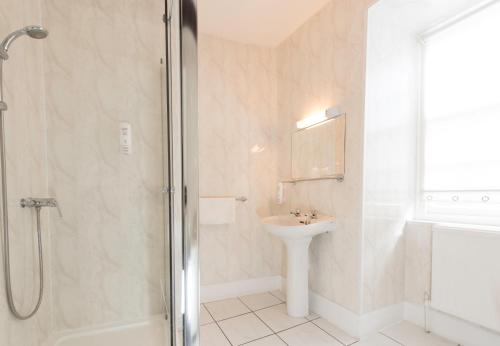 a bathroom with a shower and a sink and a toilet at The Beaufort Hotel in Chepstow