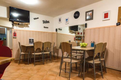 a restaurant with a table and chairs and a television at Hostel 24 in Ljubljana