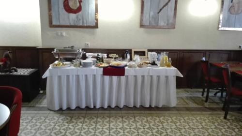 a table with a white table cloth with food on it at Hotel Bristol in Banská Štiavnica
