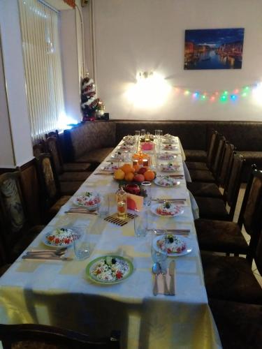 a long table with plates of food on it at Hotel Rade 1 in Vratsa