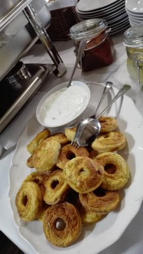 a plate of donuts on a table with a bowl of dip at Hotel Bristol in Banská Štiavnica