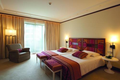 a hotel room with a large bed and a chair at Grande Real Villa Itália Hotel & Spa in Cascais