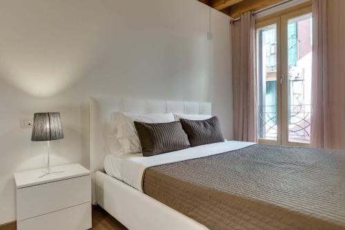Habitación blanca con cama y ventana en Appartamento Arco, en Padua