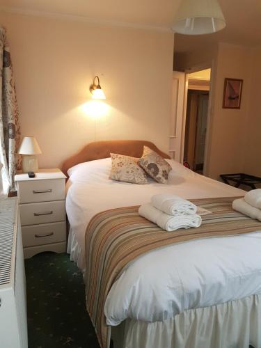 a bedroom with a bed with towels on it at Kersbrook Guest Accommodation in Lyme Regis
