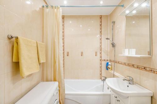 a bathroom with a sink and a toilet and a tub at Апартаменты Авион Комфорт in Kemerovo