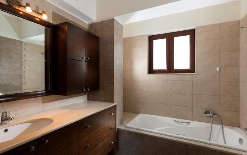 a bathroom with a sink and a bath tub at Villa Leyland in Faliraki