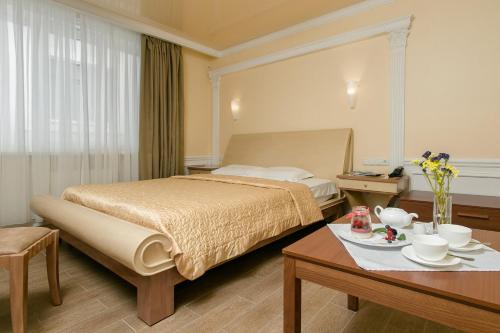 a hotel room with a bed and a table at Residence Odesskij Dvorik in Odesa