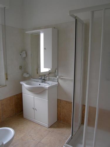 a white bathroom with a sink and a shower at Hotel Sara in Rimini