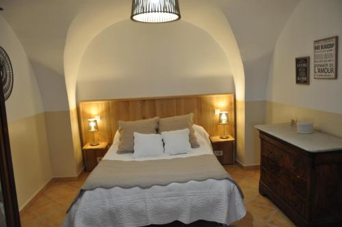 ein Schlafzimmer mit einem Bett mit zwei Kissen darauf in der Unterkunft Luc et Corine in Saint-Restitut