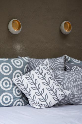a bed with pillows and two lights on the wall at Unembeza Boutique Lodge & Spa in Hoedspruit