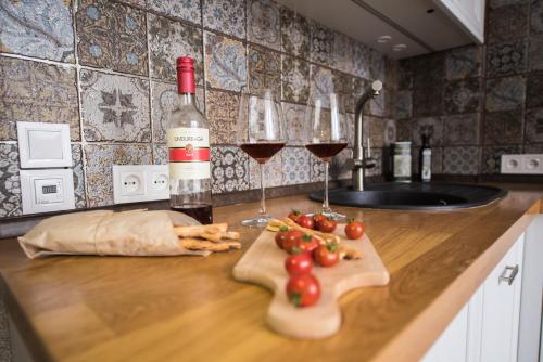 un comptoir avec deux verres de vin et quelques tomates dans l'établissement Apartment Lumen, à Kharkov