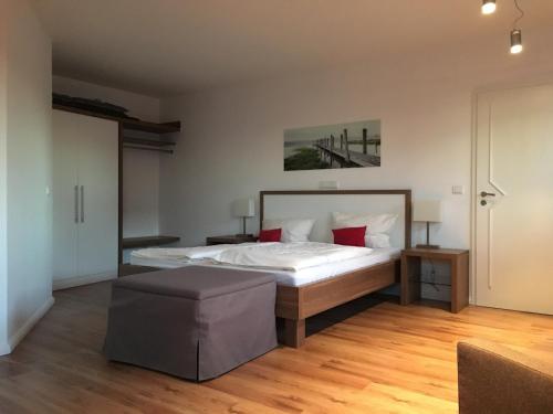 a bedroom with a bed with white sheets and red pillows at Seaside-Strandhotel in Timmendorfer Strand