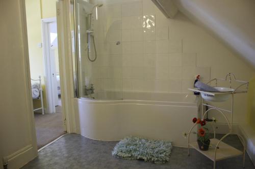 a bathroom with a shower and a bath tub at The Olde House in Dunster