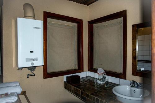 a bathroom with a sink and a toilet at Xaus Lodge in Twee Rivieren