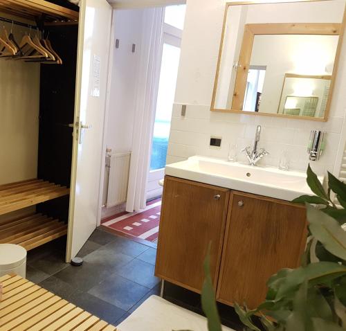 ein Bad mit einem Waschbecken und einem Spiegel in der Unterkunft B&B Wladimir Studios in Amsterdam