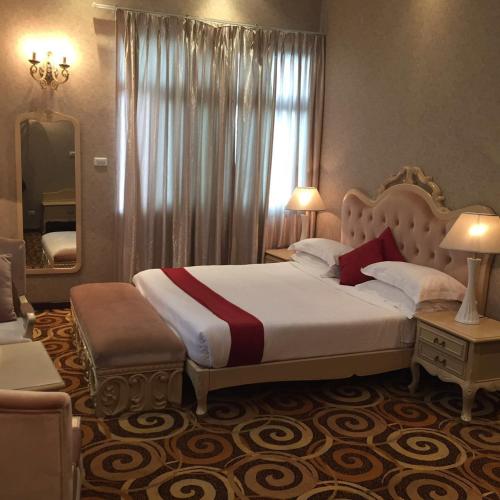 a bedroom with a large bed and a mirror at Ambassador Hotel in Addis Ababa