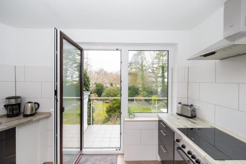 a kitchen with white appliances and a large window at Dünenhaus Steinmarne in Cuxhaven