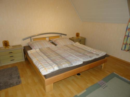 HornbachにあるHeidi's Ferienwohnungのベッドルーム1室(ベッド1台、ナイトスタンド2台付)