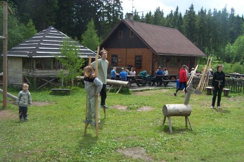 a group of people standing in a yard with a playground at Horská Chata Hříbek in Benecko