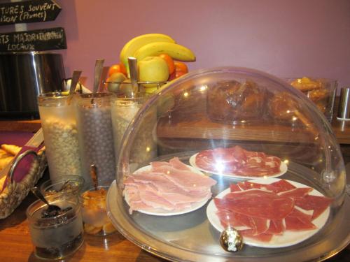 a glass plate with meat and fruit on a table at Logis Hôtel Château De Palaja in Carcassonne