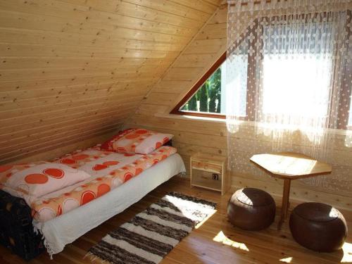 1 dormitorio con 1 cama en una cabaña de madera en Letniskowy domek z bala w Mikołajkach, en Mikołajki
