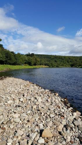 a large body of water with rocks on the shore at Mary's Apartment in Rothes