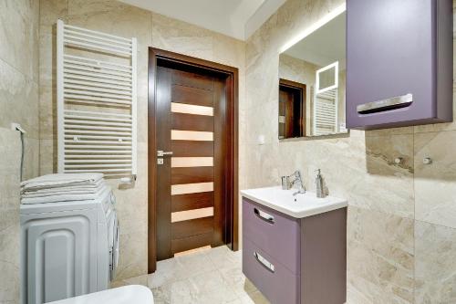 een badkamer met een wastafel, een toilet en een spiegel bij Seaside with Sunny Terrace in Gdańsk
