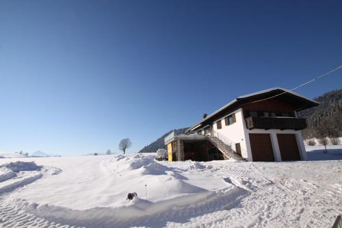 a building covered in snow in front at Pfandlhof in Walchsee