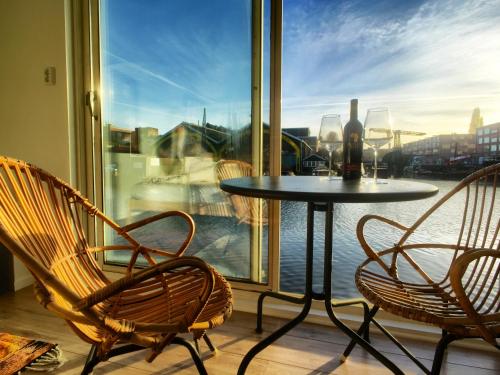 a table and chairs on a balcony with a window at Houseboat Concordia B&B in Amsterdam
