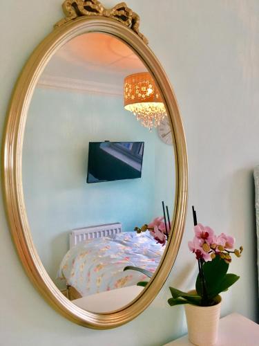 a mirror on a wall with a bed in a room at Angel's (station accommodation) in Cambridge