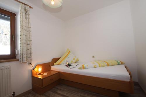 a bedroom with a bed with a lamp and a window at Pfandlhof in Walchsee
