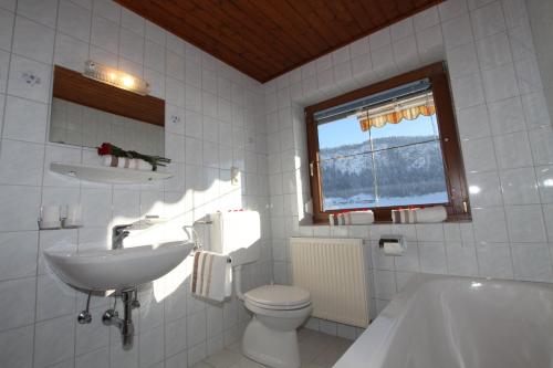 a bathroom with a sink and a toilet and a tub at Pfandlhof in Walchsee