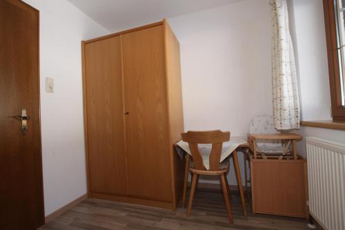 a room with a table and chairs and a cabinet at Pfandlhof in Walchsee