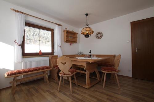 a dining room with a table and chairs and a window at Pfandlhof in Walchsee