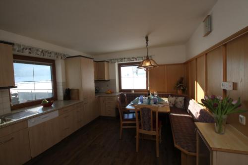 a kitchen with a table and a dining room at Pfandlhof in Walchsee