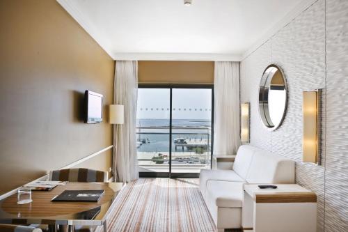 a living room with a white couch and a table at Real Marina Hotel & Spa in Olhão